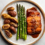 Paleo teriyaki honey glazed salmon, grilled asparagus, and roasted fingerling potatoes on a plate