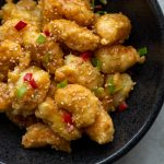 battered shrimp tossed in a creamy sauce in a bowl