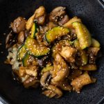 Chicken, Mushroom, and Zucchini stir fry in a black bowl