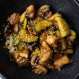Chicken, Mushroom, and Zucchini stir fry in a black bowl