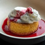Butter cake with raspberry sauce and ice cream in a bowl