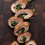 Stuffed pork tenderloin pieces on a cutting board